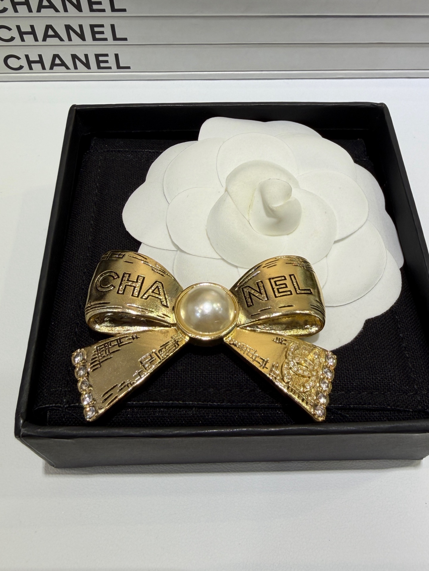 CHANEL Женская брошь бантик с цепочками и кристаллами CHANEL Женская брошь бантик с цепочками и кристаллами